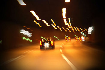 Car speeding down a road under a tunnel. 